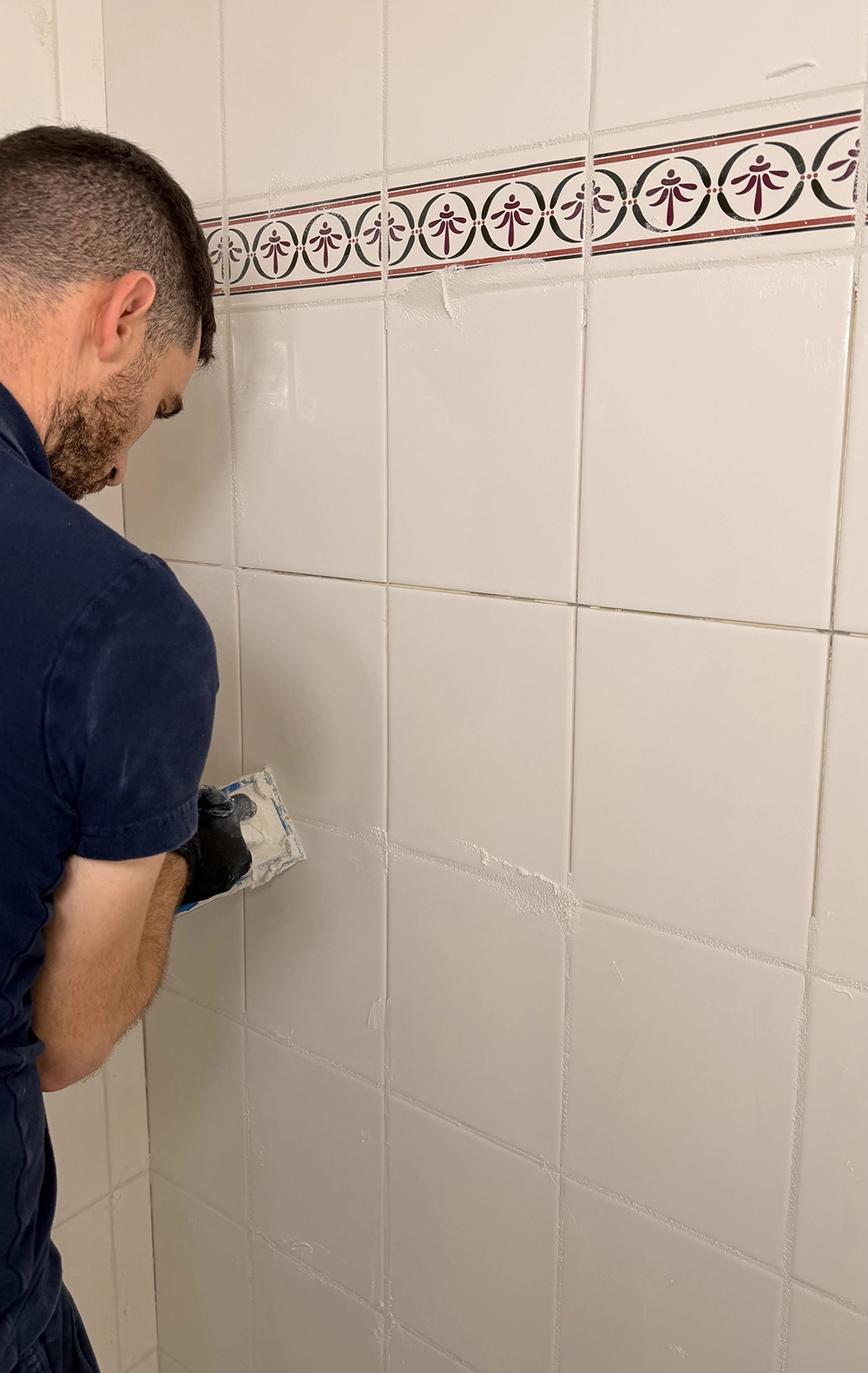 Bathroom floor flooded with water and soap bubbles from a leaking shower